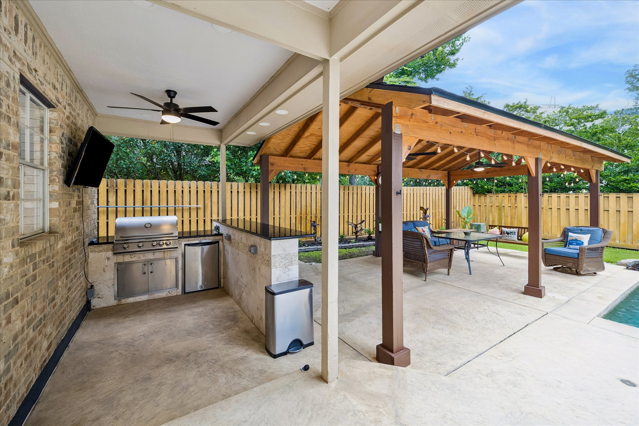15 West Beckonvale Circle The Woodlands, TX 77382 - Photo 35 of 44 An inviting outdoor kitchen sits beneath the covered back patio, while the pergola offers ample sheltered seating for relaxing or entertaining. Together, these thoughtfully designed spaces create a seamless extension of the home!