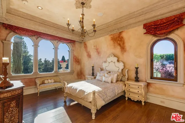 a spacious bedroom with a large bed and a chandelier