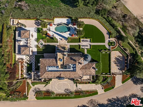an aerial view of a house with a garden and lake view