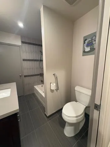 a white toilet sitting next to a bathroom sink and a shower