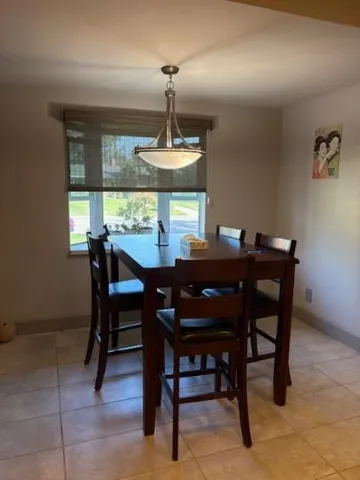 a view of a dining room with a table and chairs