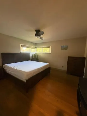 a bedroom with a bed and a ceiling fan