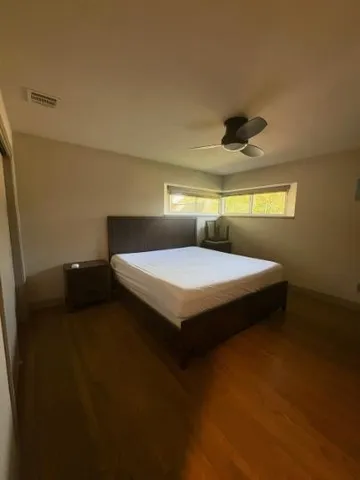 a bedroom with a bed and a ceiling fan