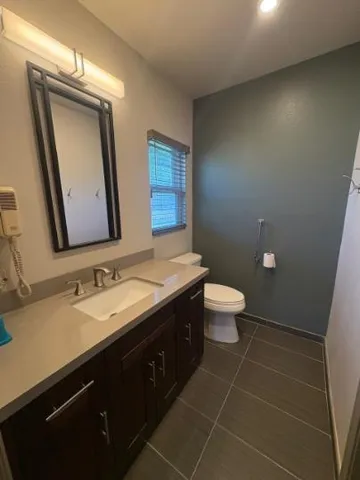 a bathroom with a double vanity sink toilet and a mirror