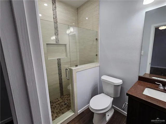 a bathroom with a toilet a sink a shower and mirror