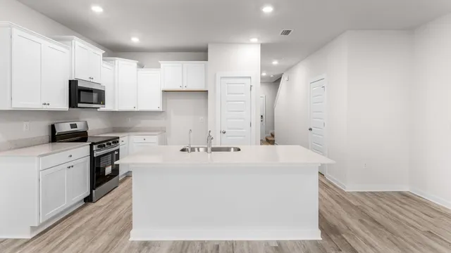a kitchen with stainless steel appliances a sink stove and refrigerator