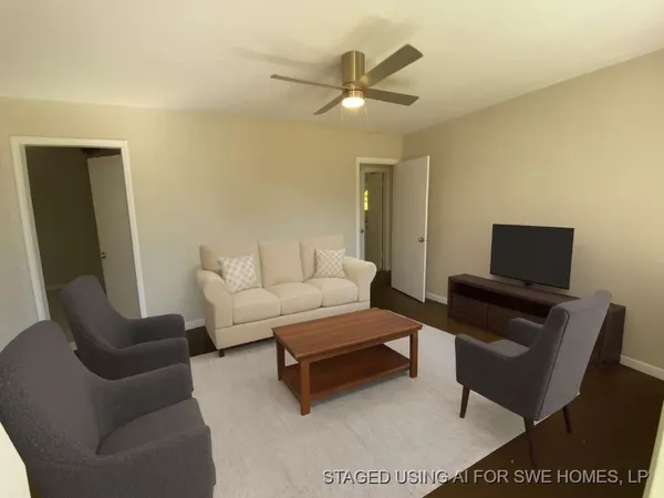 a living room with furniture a rug and a ceiling fan