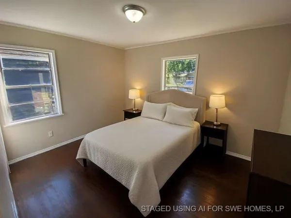 a bedroom with a bed and a lamp next to a window