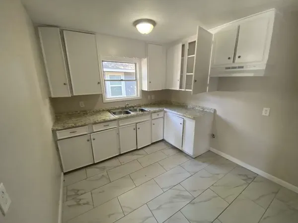 a kitchen with a sink window and cabinets