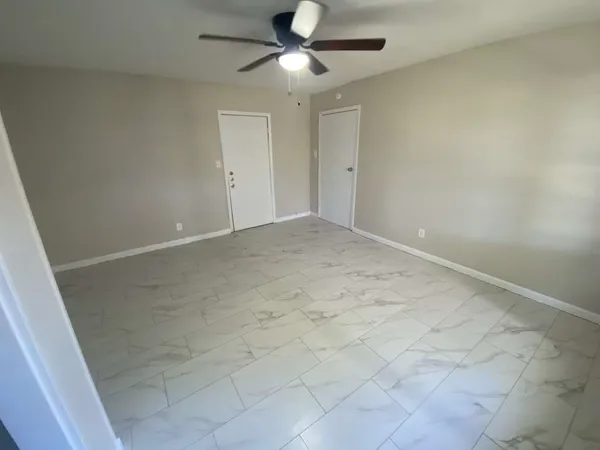 an empty room with fan and entrance