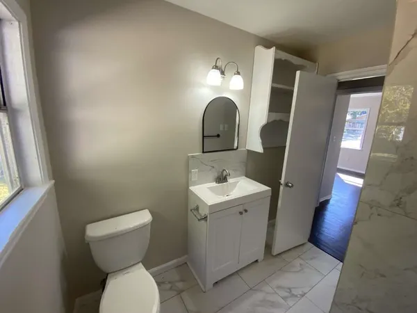 a bathroom with a toilet sink and mirror