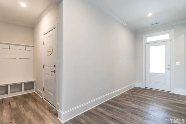 an empty room with wooden floor and entrance