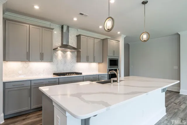 a kitchen with stainless steel appliances granite countertop a sink a stove and a refrigerator