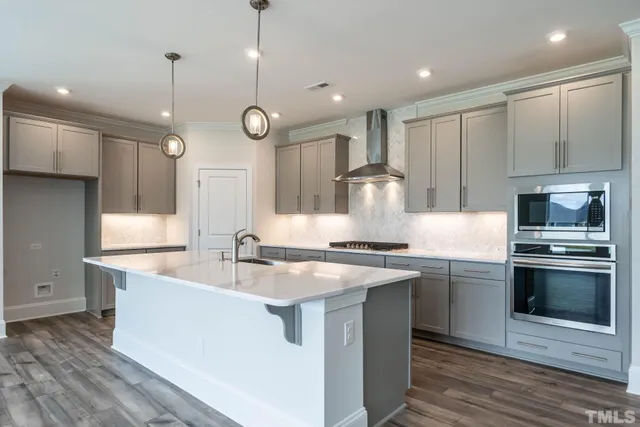 a kitchen with stainless steel appliances granite countertop a sink a stove and a refrigerator