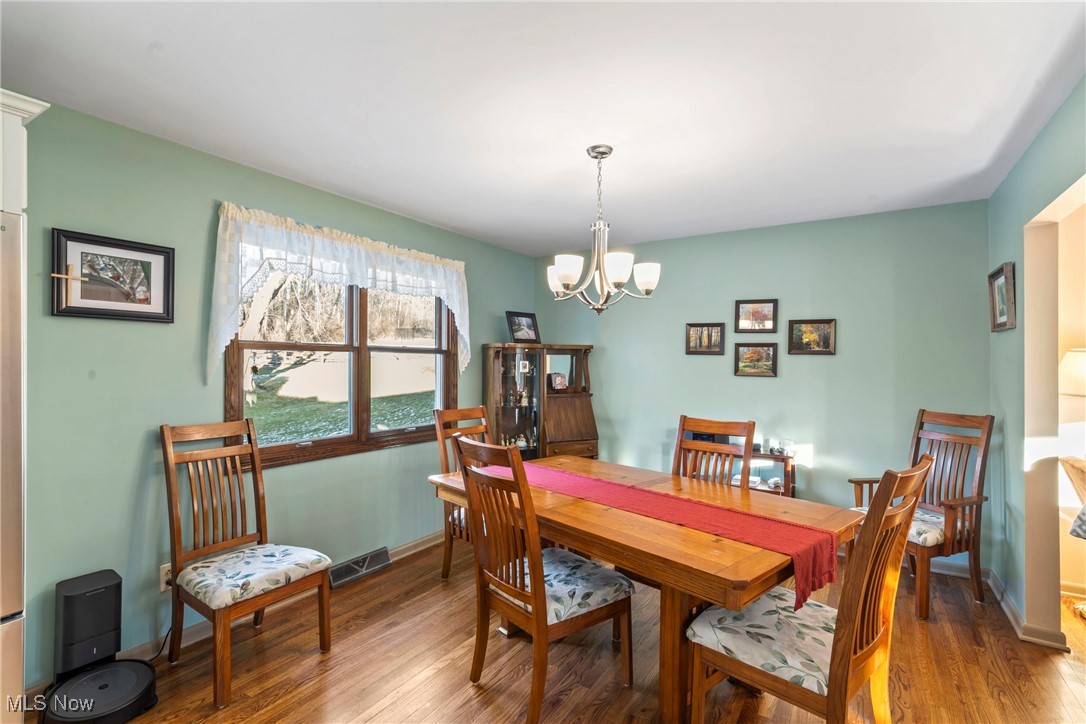 3401 Barrett Road Akron, OH 44333 - Photo 8 of 24 Dining space featuring wood-type flooring and a notable chandelier