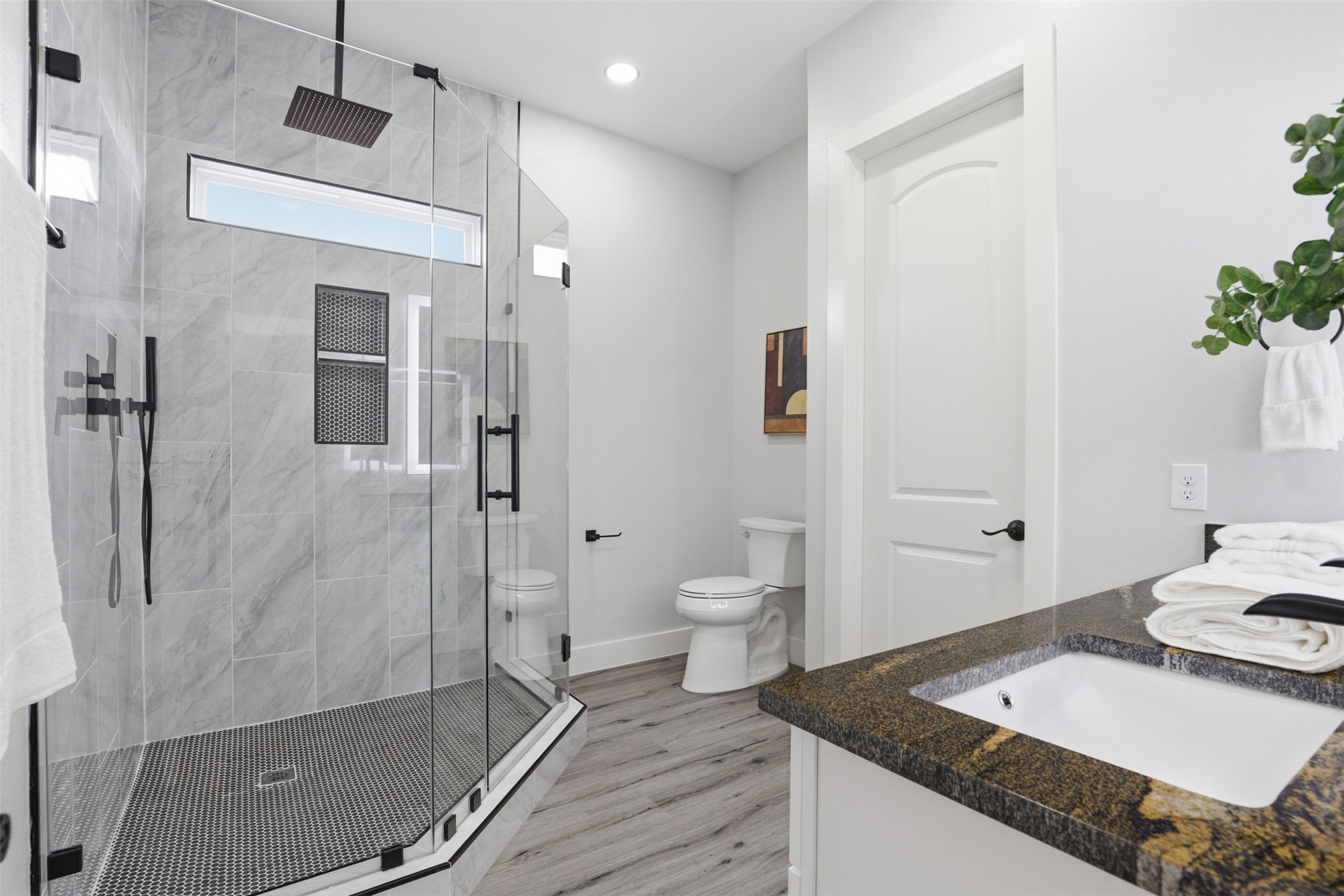 113 Los Robles Road Elgin, TX 78621 - Photo 11 of 20 Modern bathroom featuring a glass-enclosed shower with matte black fixtures, an overhead rain shower, and a built-in shower niche