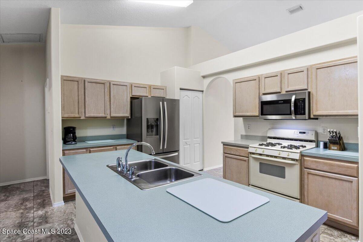 2405 Ruffner Road Melbourne, FL 32901 - Photo 14 of 35 a kitchen with a stove a sink and a refrigerator