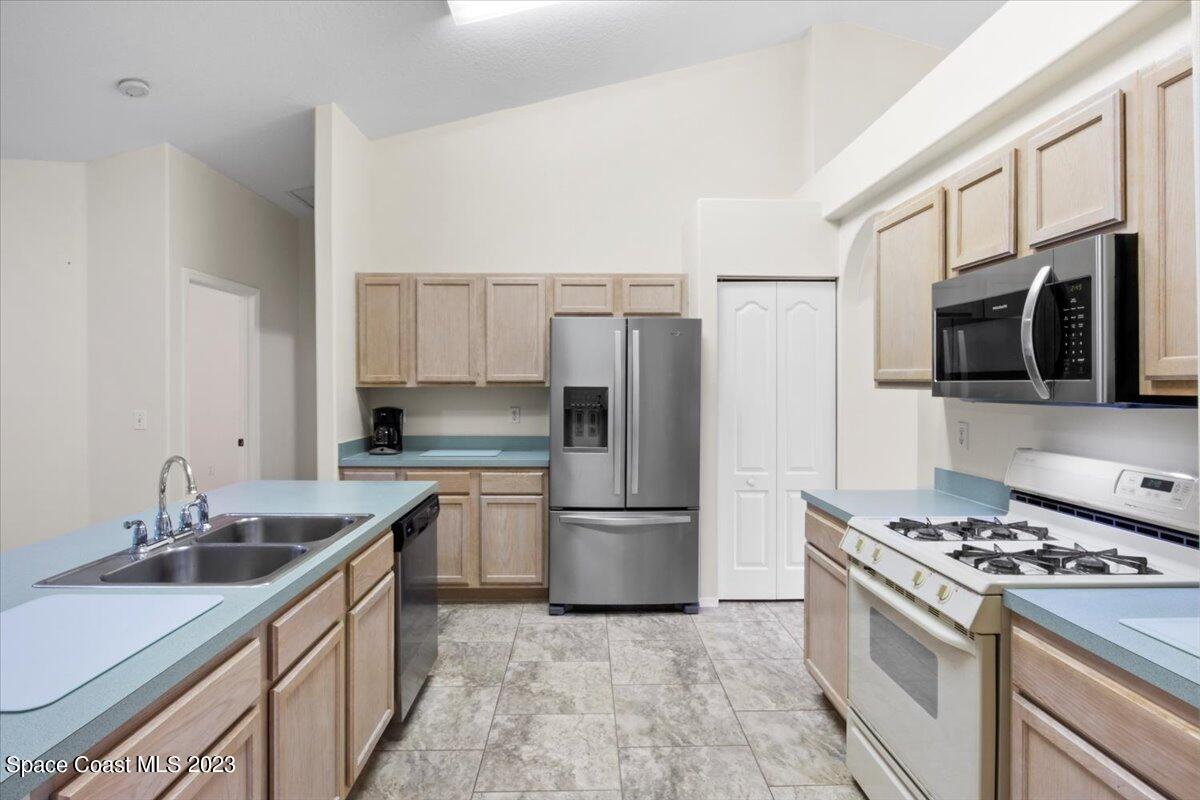 2405 Ruffner Road Melbourne, FL 32901 - Photo 15 of 35 a kitchen with stainless steel appliances granite countertop a sink stove and refrigerator