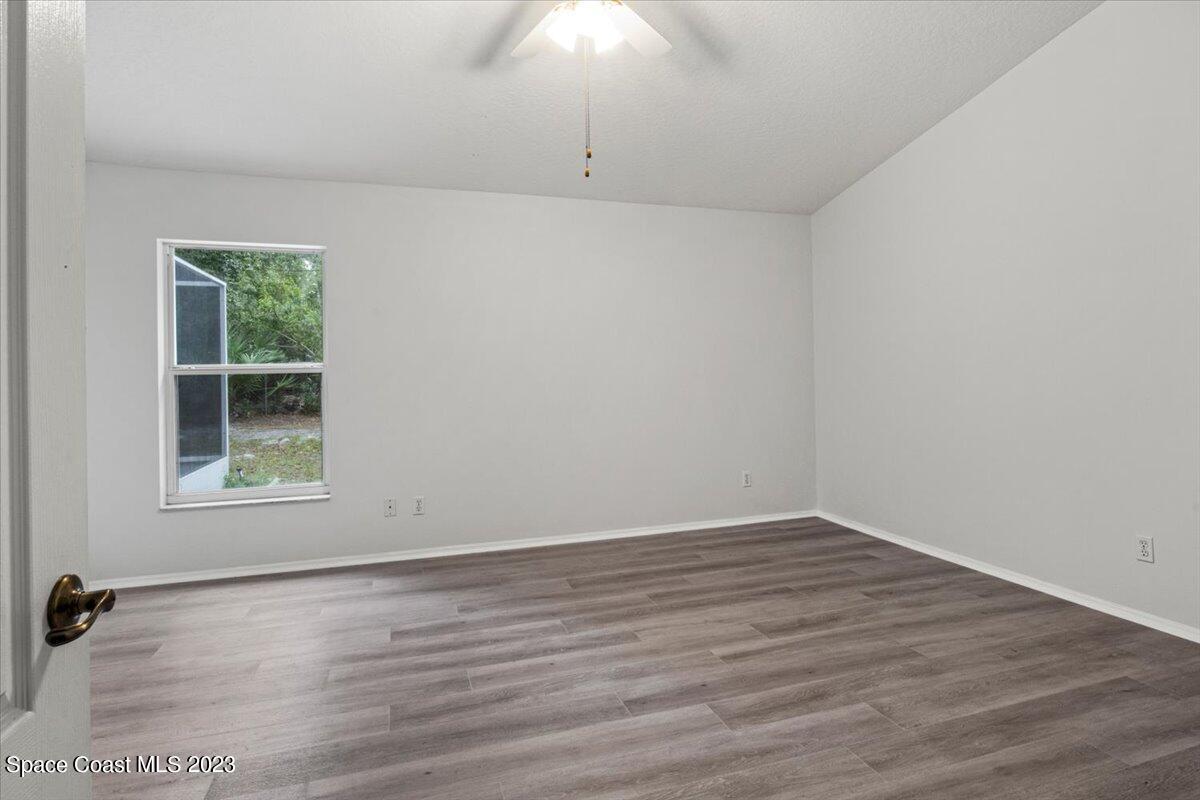 2405 Ruffner Road Melbourne, FL 32901 - Photo 16 of 35 an empty room with wooden floor and windows