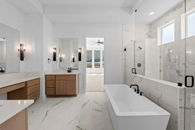 a spacious bathroom with a tub sink shower and mirror
