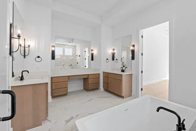 a spacious bathroom with a double vanity sink a mirror a bathtub and shower