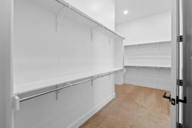 a view of walk in closet with empty racks