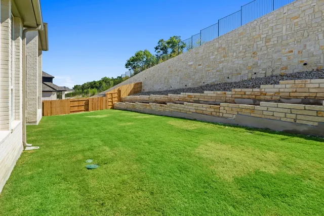 a view of a backyard with a garden and entertaining space