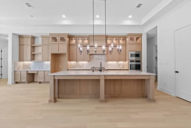 a large kitchen with granite countertop a large counter top stainless steel appliances and cabinets