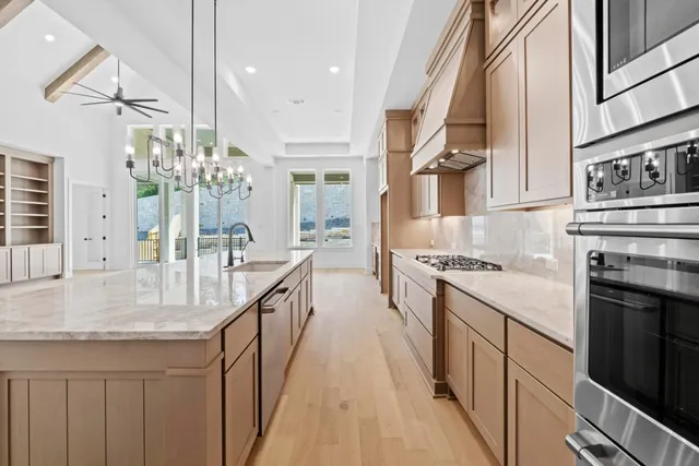 a kitchen with stainless steel appliances granite countertop a lot of counter space and wooden floors