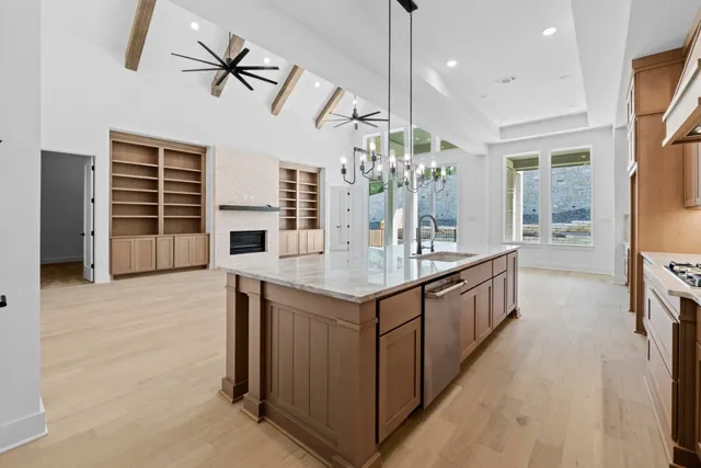 a kitchen with stainless steel appliances granite countertop a sink and a refrigerator