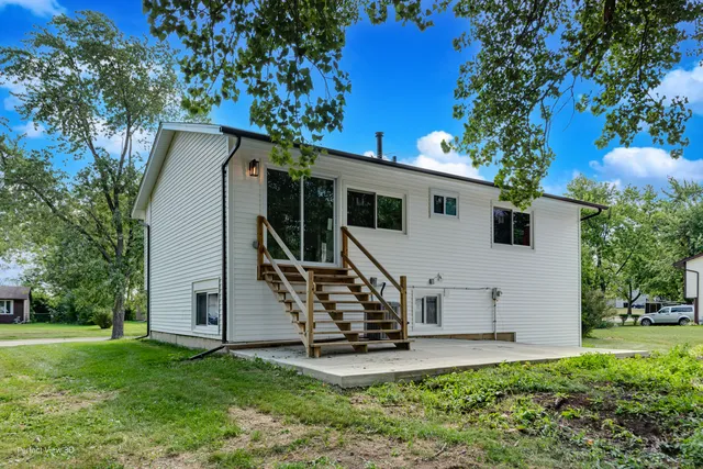 a view of a house with backyard and a tree