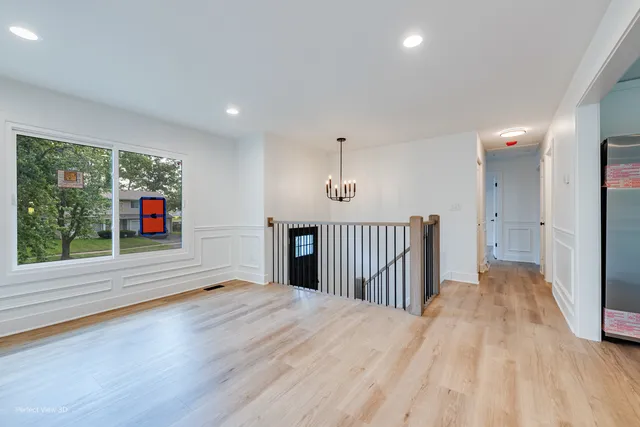 a view of empty room with wooden floor and windows