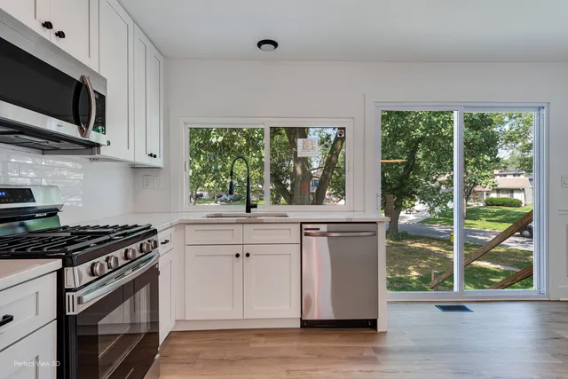 a kitchen with stainless steel appliances a stove a sink and a microwave