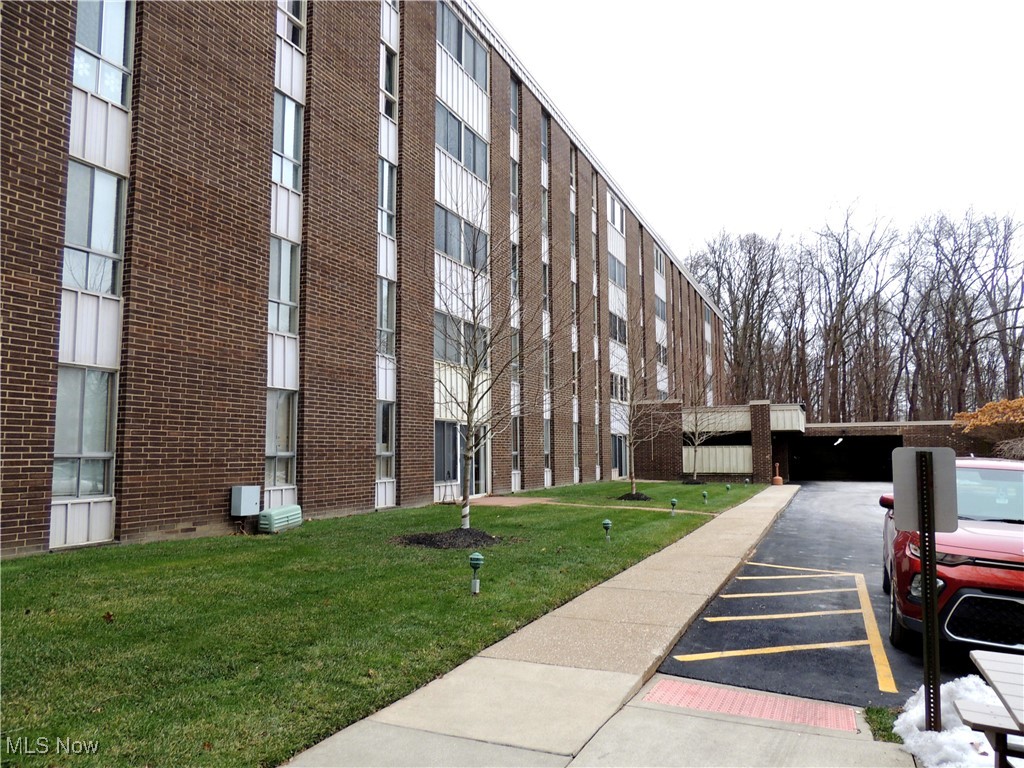 View of apartment building / complex with uncovered parking