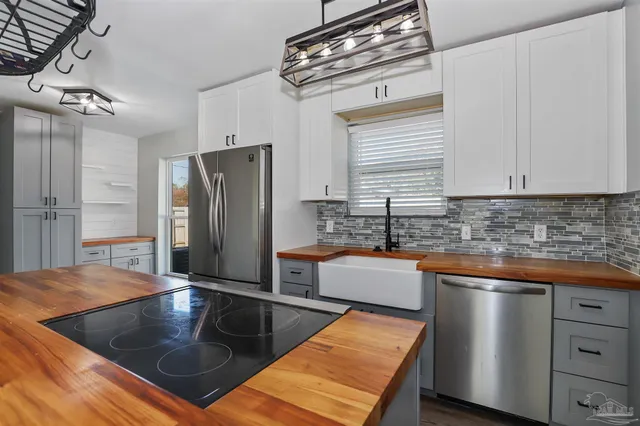 a kitchen with stainless steel appliances granite countertop a sink a stove and a refrigerator