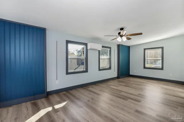 a view of an empty room with chandelier and window