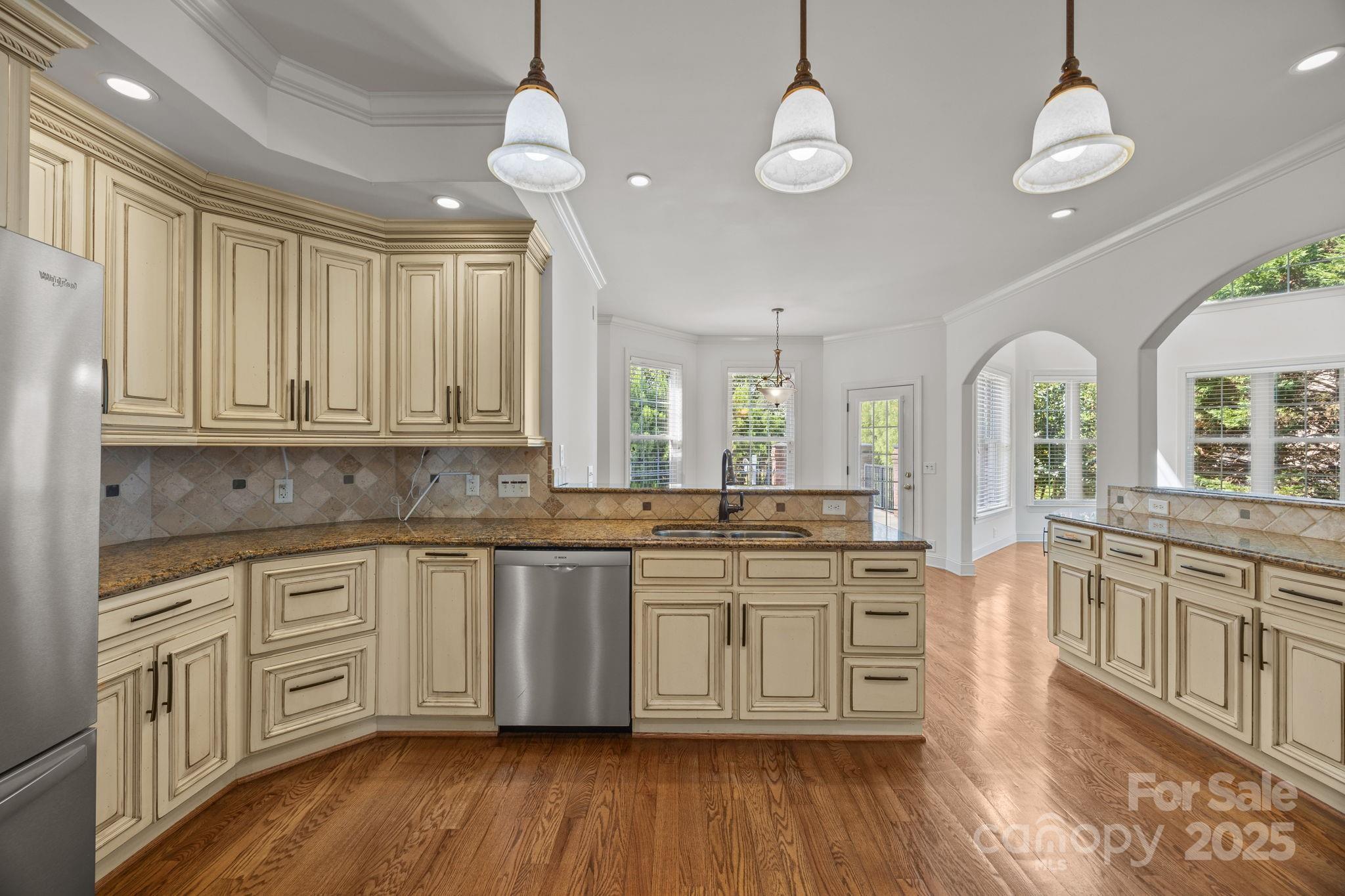 110 Devonshire Lane Salisbury, NC 28146 - Photo 17 of 48 a large kitchen with cabinets a sink dishwasher a dining table and chairs with wooden floor
