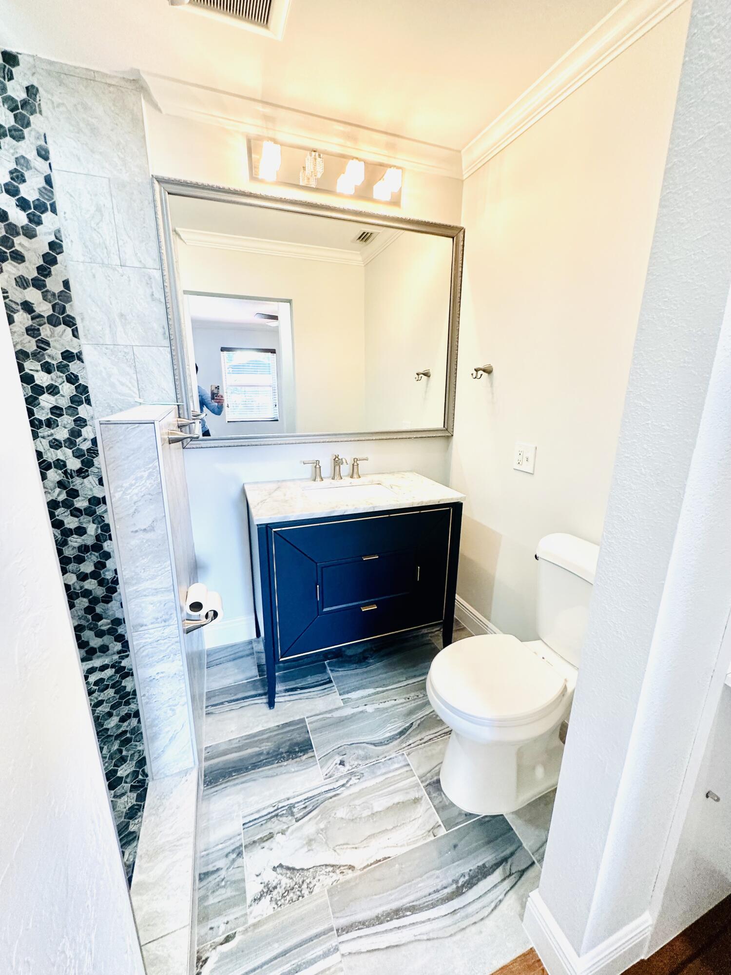 1104 Neoga Street Jupiter, FL 33458 - Photo 16 of 21 a bathroom with a toilet a sink and a mirror