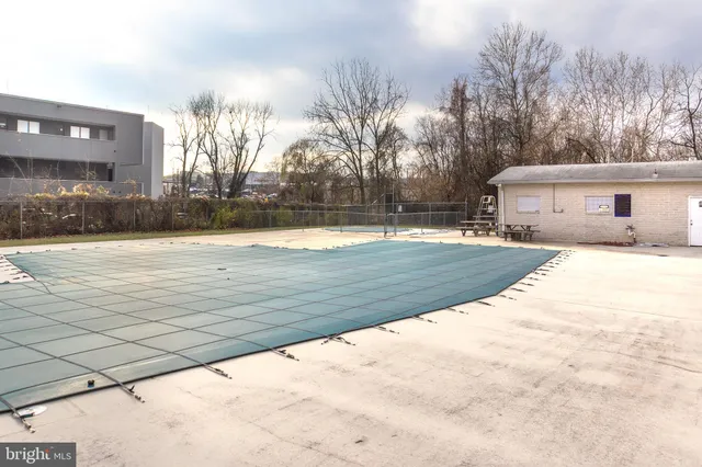 a view of swimming pool with outdoor space and trees in the background