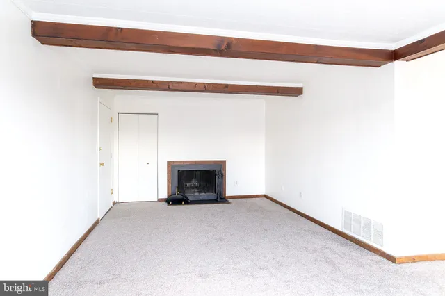 a view of empty room with a fireplace