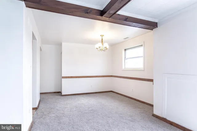 an empty room with windows and chandelier