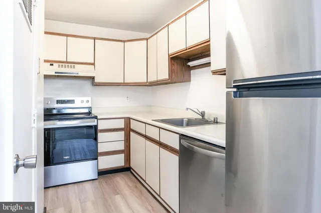 a kitchen with stainless steel appliances a refrigerator sink and cabinets