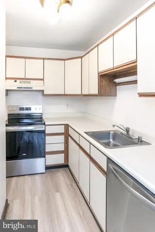 a kitchen with granite countertop a sink a stove and cabinets