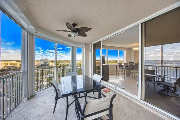 a dining room with furniture water view and a floor to ceiling window
