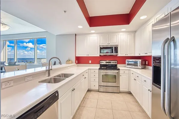 a kitchen with granite countertop a sink stainless steel appliances and cabinets