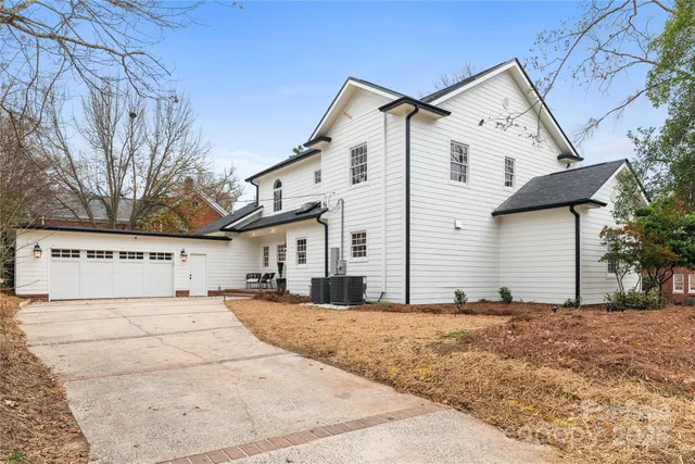 a view of a white house with a large tree in front of it