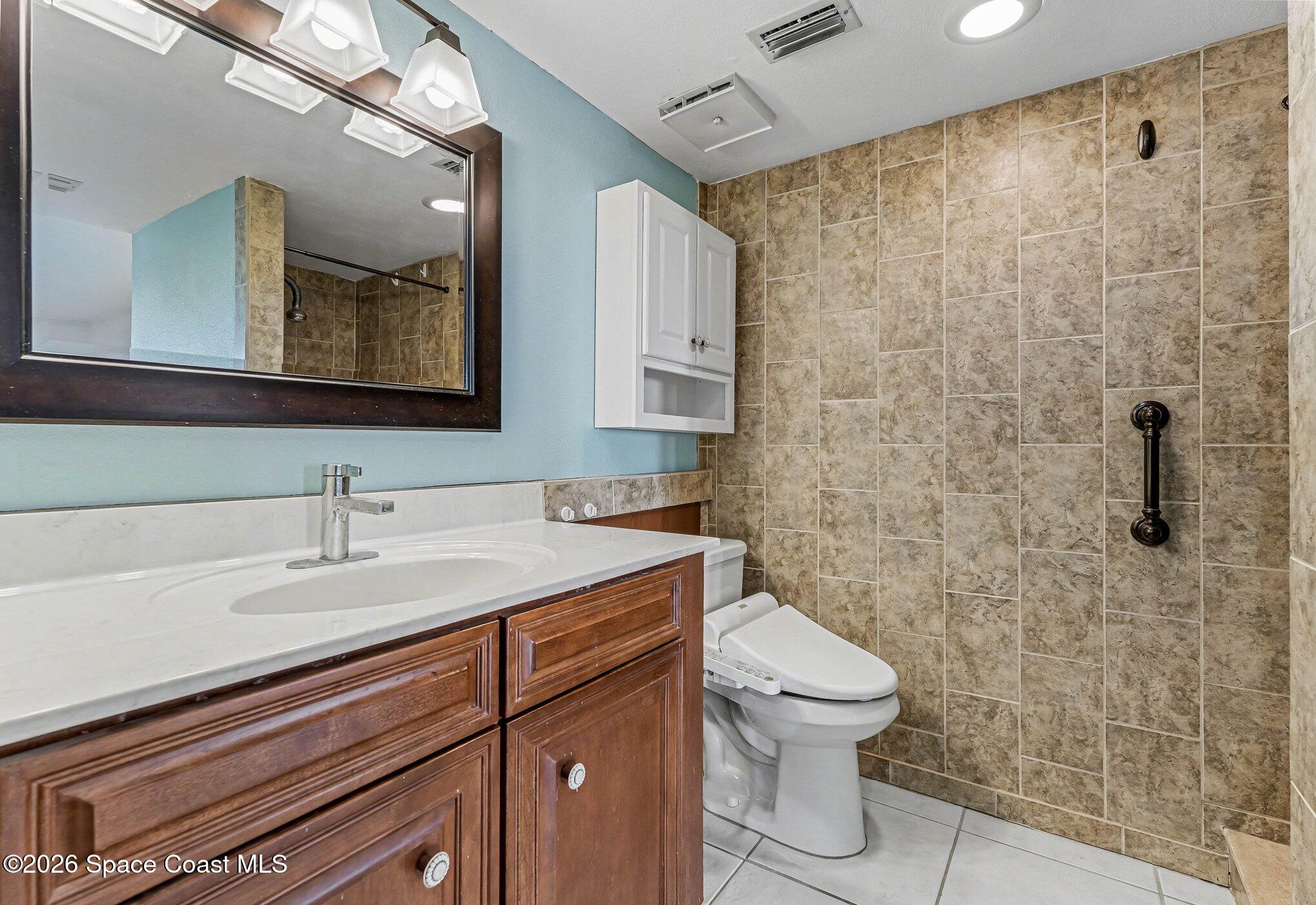 100 Canebreakers Drive, Unit 108 Cocoa, FL 32927 - Photo 11 of 17 a bathroom with a sink a toilet and shower