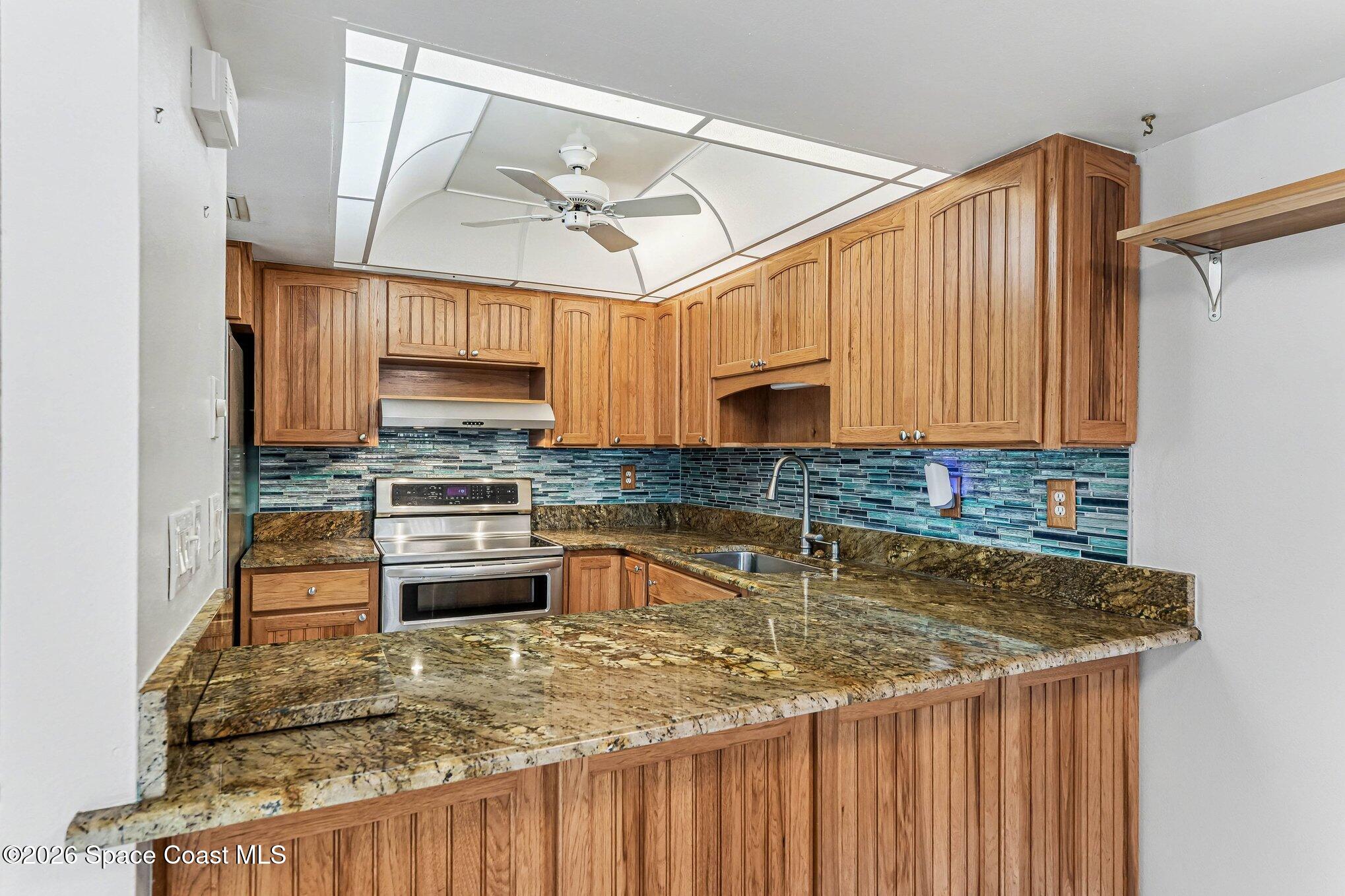 100 Canebreakers Drive, Unit 108 Cocoa, FL 32927 - Photo 5 of 17 a kitchen with stainless steel appliances granite countertop a sink window and cabinets