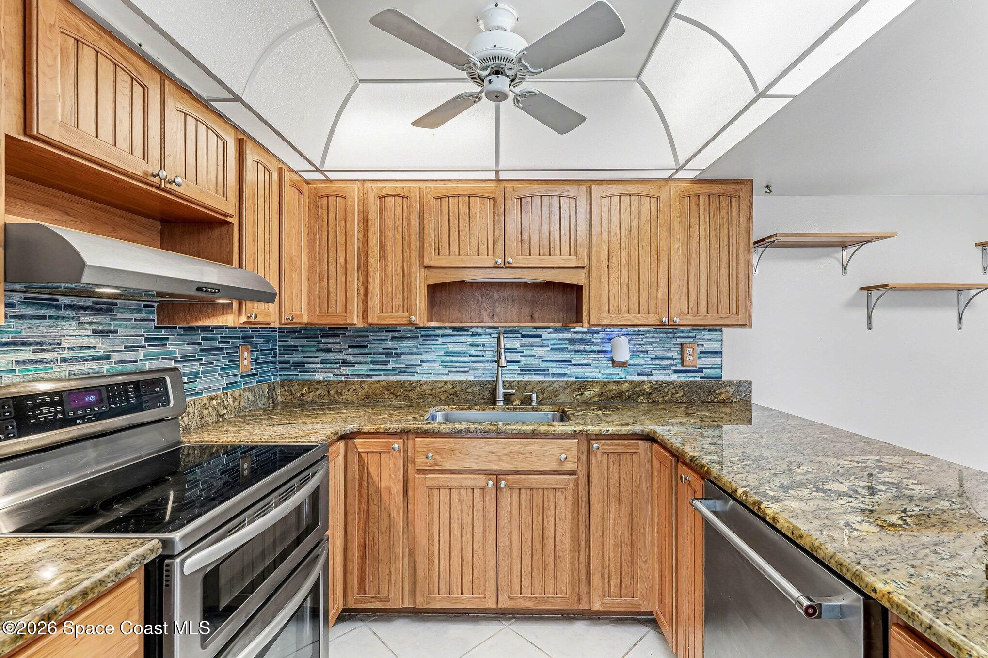 100 Canebreakers Drive, Unit 108 Cocoa, FL 32927 - Photo 6 of 17 a kitchen with granite countertop a sink stainless steel appliances and cabinets