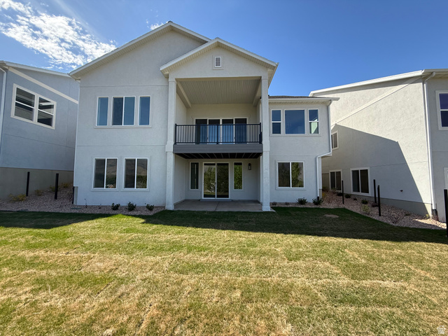 624 North Legend Circle, Unit 480 Mapleton, UT 84664 - Photo 28 of 34 Back of house featuring stucco siding, a lawn, a patio area, and a balcony